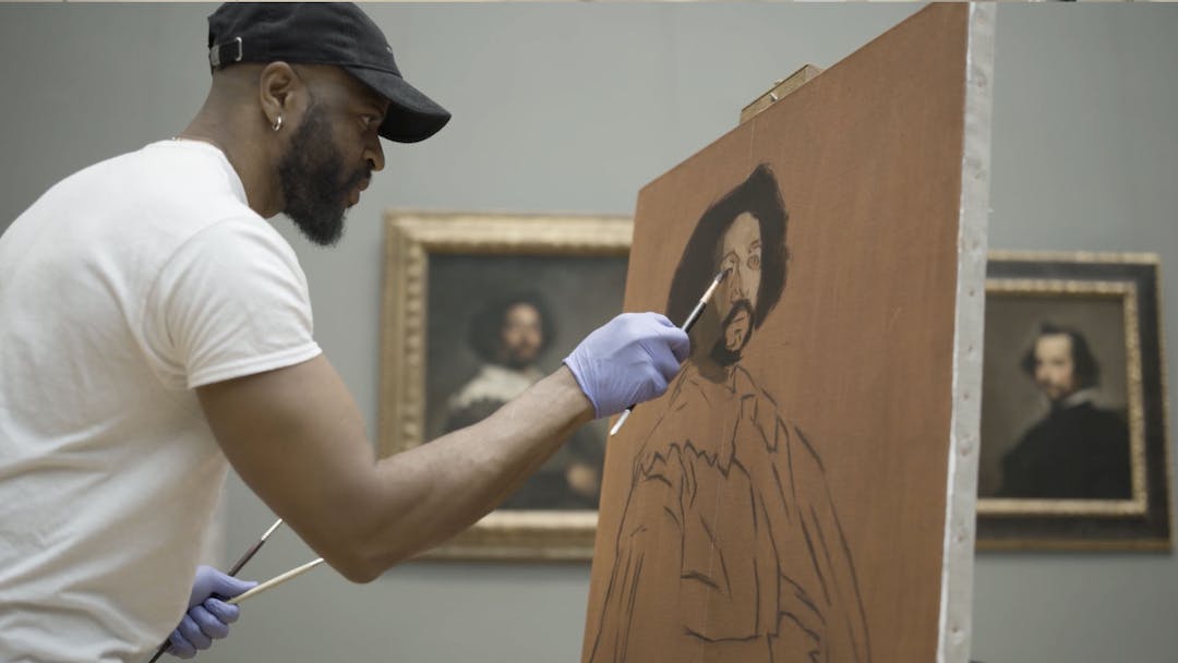 Contemporary artist Jas Knight, a black man, paints on a toned canvas as he copies Diego Velazquez’s Juan de Pareja (1650) at The Met's European Painting galleries.