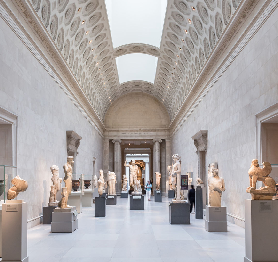A view of The Met's Greek and Roman sculptures which line a sweeping hallway.